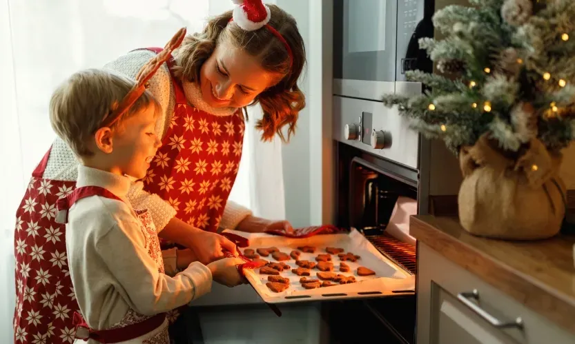 kids putting cookies in oven